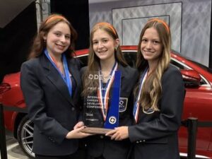 DECA students holding an award